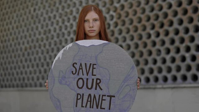 Young woman holding cardboard with save our planet phrase