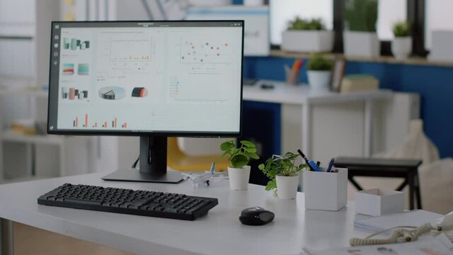 Nobody at desk in company office with computer and tools. Empty workplace for business meeting and work with data charts and research on monitor. Corporate space for project planning