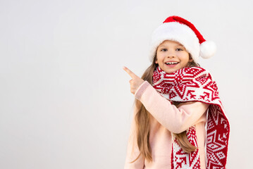 A little girl in a New Year's hat points her finger at the advertisement.