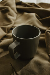 Empty grey coffee cup on beige background isolated. Close-up image. Concept of coffee.