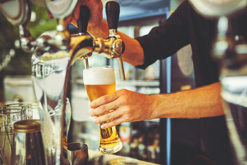 Bartender Serving Customers In Busy Bar