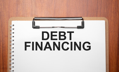 Debt financing text on white paper on the wood table