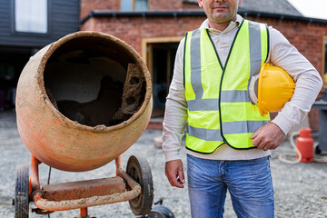 Contractor next to a cement mixer