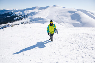 man snowboarder at the top of the mountains