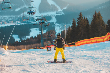 man snowboarder at the top of the slope. beautiful winter mountains. winter vacation