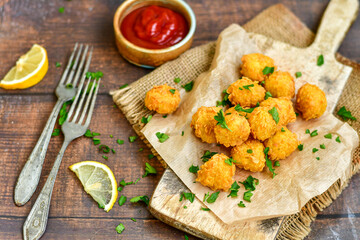 
 Crispy  deep fried home made    chicken  nuggets .Breaded  with  almond flour chicken  breast fillets  with chilly peppers and fresh   basil on wooden rustic background. Ketogenic diet food