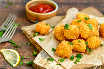 
 Crispy  deep fried home made    chicken  nuggets .Breaded  with  almond flour chicken  breast fillets  with chilly peppers and fresh   basil on wooden rustic background. Ketogenic diet food