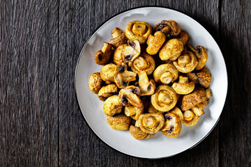 grilled juicy mushrooms on a plate, top view