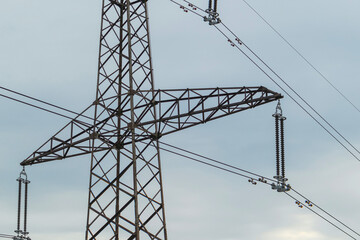 Close-up view of a high-voltage line electricity pole. Electricity pole and wires on a sky background