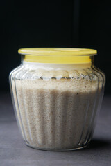  Psyllium Seeds 0n a container on dark background