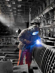A welder at work in a shipyard. - obrazy, fototapety, plakaty