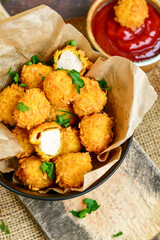 
 Crispy  deep fried   chicken   popcorns  Breaded  with cornflakes chicken  breast fillets  with chilly peppers and fresh   basil on wooden rustic background