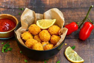 
 Crispy  deep fried   chicken   popcorns  Breaded  with cornflakes chicken  breast fillets  with chilly peppers and fresh   basil on wooden rustic background