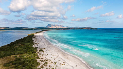 famous La Cinta beach overlooking the island of Tavolara. white sandy beach and soft blue water. very popular with tourists, kiters, great for a romantic walk. drone aerial view, Sardinia Italy.