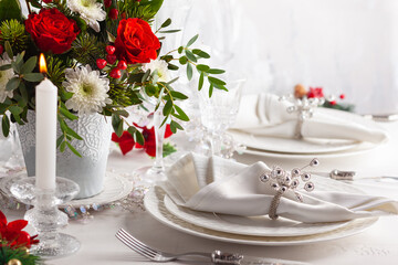 Christmas or New Year table setting with bouquets of flower and festive decorations.