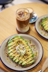 breakfast of avocado toast with egg and coffee with milk