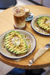breakfast of avocado toast with egg and coffee with milk