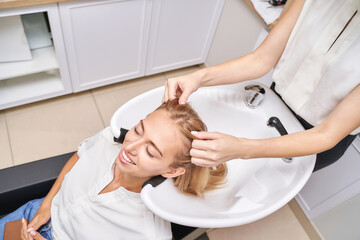 Long hair procedure. Hairwash at salon. Woman master. Hand with towel. Adult female person. Studio...