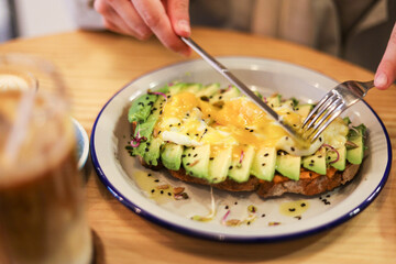 breakfast of avocado toast with egg and coffee with milk