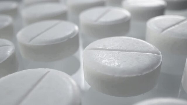 Macro shot of medications tablets drugs on a white soft background. Treatment pharmacology oncept.