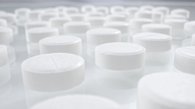Macro shot of medications tablets drugs on a white soft background. Treatment pharmacology oncept.