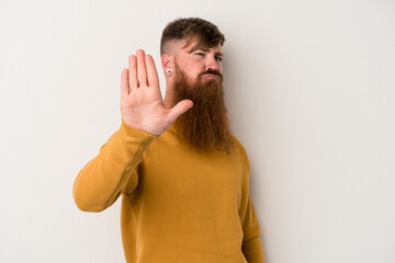 Young caucasian ginger man with long beard isolated on white background rejecting someone showing a gesture of disgust.