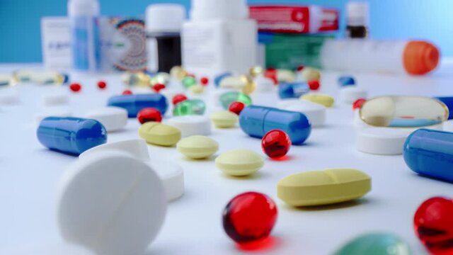 Macro shot of medications pills and tablets spilled out of pill container. Multicolored drugs Probe lens shot.