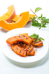 sweet baked grilled pumpkin with seeds in a plate