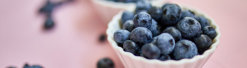 Banner Flat lay of fresh organic juicy blueberries in a bowl on pink background