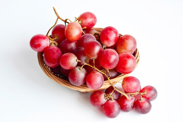 Red grape in an old basket on white background. Healthy food