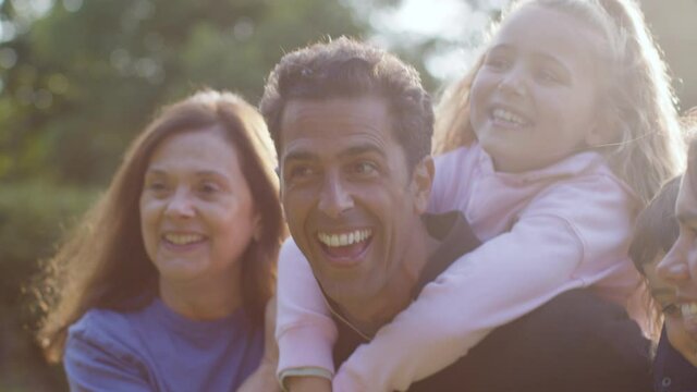Close Up Shot of Family Giving Piggy Backs to Their Children and Laughing 02