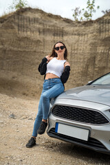 Fototapeta premium seductive woman posing near car in summer outside the city