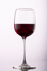 pouring red wine into glass with highlights on red background