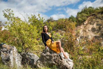 cute woman lying on a large stone at sand quarry