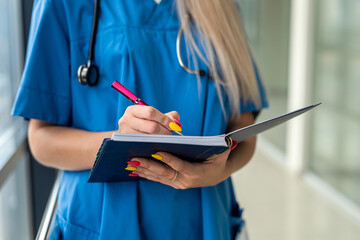 young beautiful nurse stands in the hallway with a stethoscope and a tablet