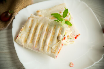 baked pita roll with filling in a plate on the table