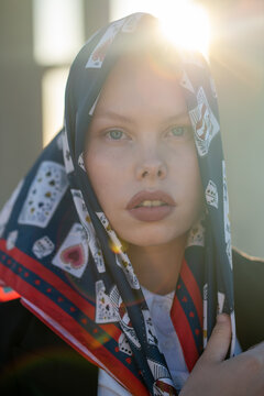 Perfect imperfection. Caucasian curvy model wearing a silk headscarf. Sunlight in background. Natural beauty.