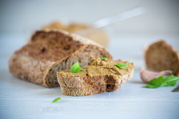 homemade liver pate with bread on a wooden table