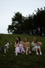 Obraz premium girlfriends smiling in nature in colorful dresses during spring