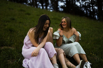 girlfriends smiling in nature in colorful dresses during spring