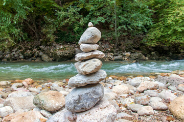 A pyramid of stones near the river, symbolizing Zen harmony and balance.