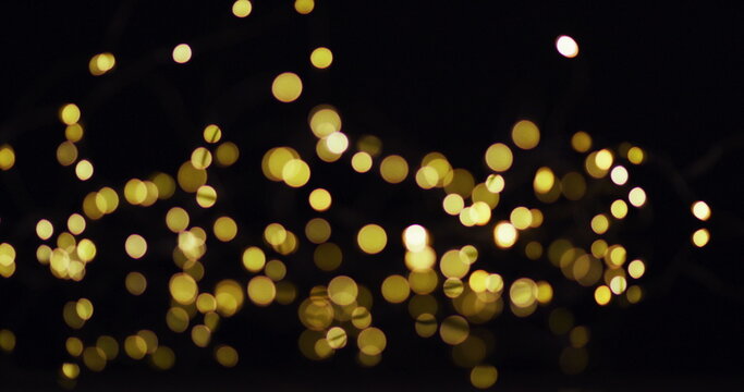 Multiple gold fairy lights glowing on black background