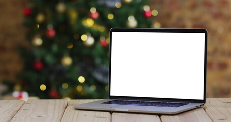 Laptop with copy space on screen, with christmas decorations and tree