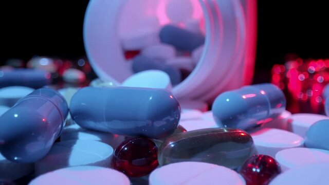 Macro shot of medications pills and tablets spilled out of pill container. Multicolored drugs Probe lens shot.