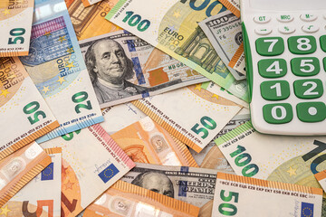 Obraz na płótnie Canvas calculator on dollar and the euro bills, exchange money