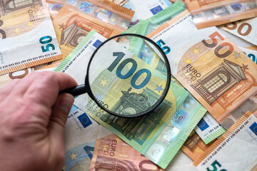 euro bills with magnifying glass, finance concept