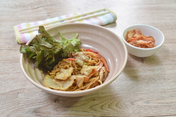 fried yakisoba Japanese noodles slice pork and cabbage with carrot on bowl eat couple pickled vegetable in cup