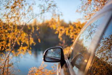 car in the autumn forest on the lake