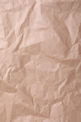 Texture of wrinkled kraft paper bag as background, closeup