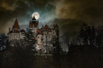 Moon in the clouds over Bran Castle, Transylvania, Romania. Medieval building, Dracula's Castle....